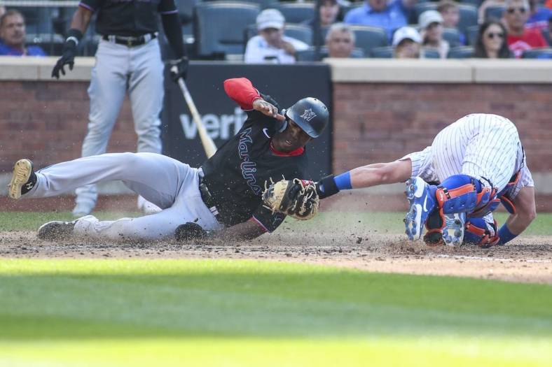 Jul 9, 2022; New York City, New York, USA;  Miami Marlins center fielder Jesus Sanchez (7) is tagged out at home by New York Mets catcher James McCann (33) in the sixth inning at Citi Field. Mandatory Credit: Wendell Cruz-USA TODAY Sports