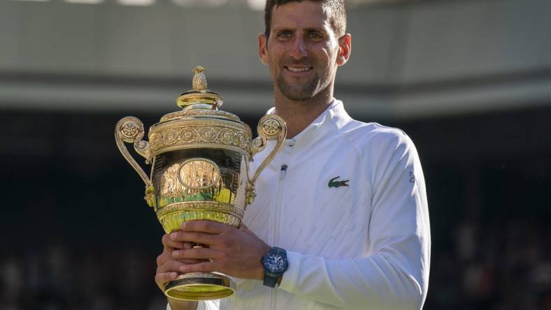 Jul 10, 2022; London, United Kingdom; Novak Djokovic (SRB) poses with the trophy after winning the men   s final against Nick Kyrgios (not pictured) on day 14 at All England Lawn Tennis and Croquet Club. Mandatory Credit: Susan Mullane-USA TODAY Sports