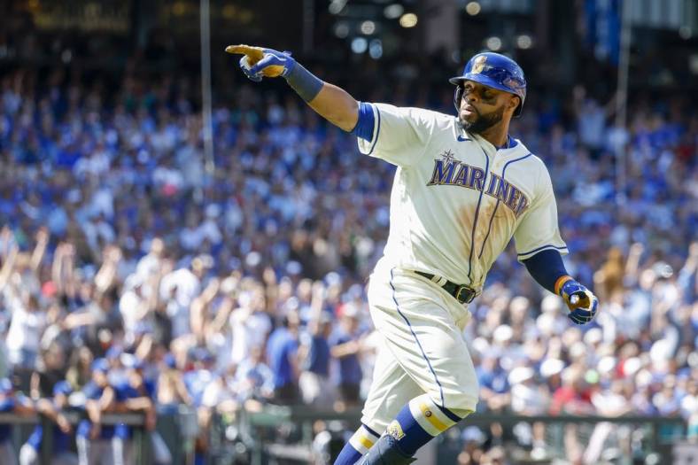 Jul 10, 2022; Seattle, Washington, USA; Seattle Mariners first baseman Carlos Santana (41) points to the dugout as he runs the bases after hitting a two-run home run against the Toronto Blue Jays during the eighth inning at T-Mobile Park. Mandatory Credit: Joe Nicholson-USA TODAY Sports