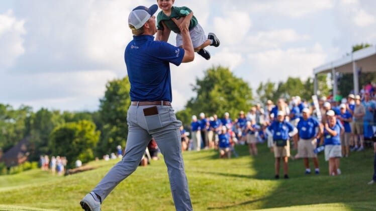 Jul 10, 2022; Nicholasville, Kentucky, USA; Trey Mullinax lifts up his two-year-old son Jude on the 18th green during the final round of the Barbasol Championship golf tournament. Mandatory Credit: Jordan Prather-USA TODAY Sports