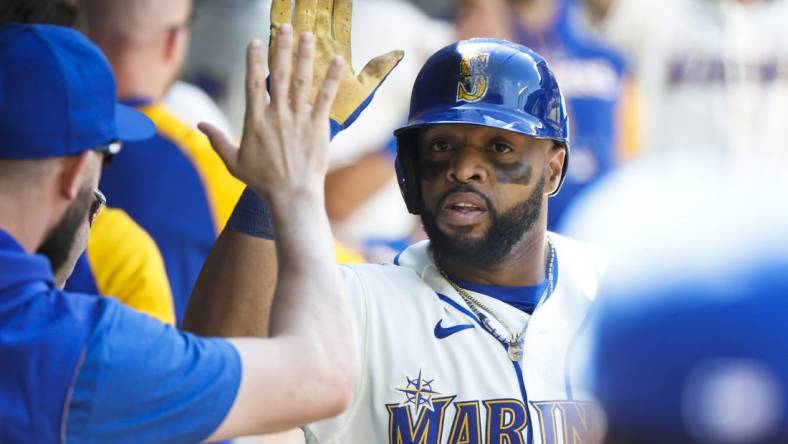 Jul 10, 2022; Seattle, Washington, USA; Seattle Mariners first baseman Carlos Santana (41) high-fives teammates in the dugout following a two-run home run against the Toronto Blue Jays during the eighth inning at T-Mobile Park. Mandatory Credit: Joe Nicholson-USA TODAY Sports