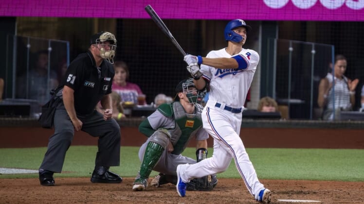Jul 11, 2022; Arlington, Texas, USA; Texas Rangers shortstop Corey Seager (5) hits a home run against the Oakland Athletics during the fifth inning at Globe Life Field. Mandatory Credit: Jerome Miron-USA TODAY Sports