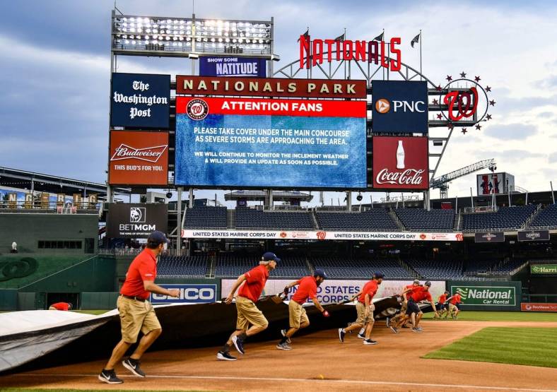 Jul 12, 2022; Washington, District of Columbia, USA; Washington Nationals grounds crew puts the tarp on the field before the game between the Washington Nationals and the Seattle Mariners at Nationals Park. Mandatory Credit: Brad Mills-USA TODAY Sports