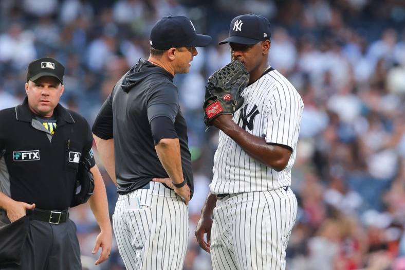 Jul 13, 2022; Bronx, New York, USA; New York Yankees manager Aaron Boone (17) talks with starting pitcher Luis Severino (40) during the second inning against the Cincinnati Reds at Yankee Stadium. Mandatory Credit: Vincent Carchietta-USA TODAY Sports