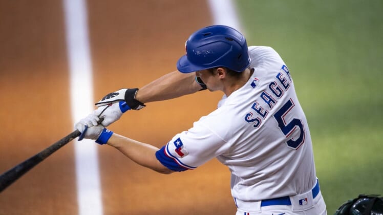 Jul 13, 2022; Arlington, Texas, USA; Texas Rangers designated hitter Corey Seager (5) drives in a run against the Oakland Athletics during the first inning at Globe Life Field. Mandatory Credit: Jerome Miron-USA TODAY Sports
