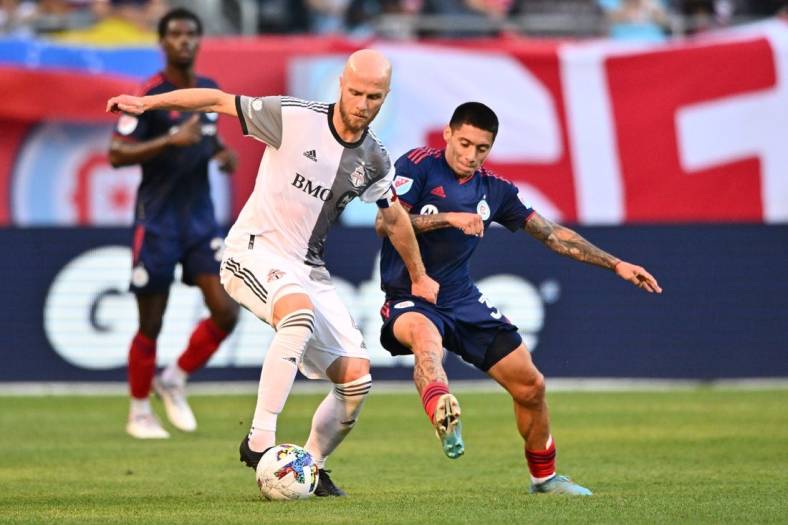 Jul 13, 2022; Chicago, Illinois, USA;  Toronto FC midfielder Michael Bradley (4) and Chicago Fire FC midfielder Federico Navarro (31) battle for control of the ball in the first half at Soldier Field. Mandatory Credit: Jamie Sabau-USA TODAY Sports