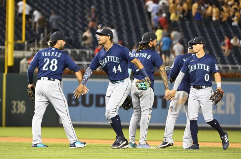 Jul 13, 2022; Washington, District of Columbia, USA; Seattle Mariners center fielder Julio Rodriguez (44) and third baseman Eugenio Suarez (28) and right fielder Sam Haggerty (0) celebrate after the game against the Washington Nationals at Nationals Park. Mandatory Credit: Brad Mills-USA TODAY Sports