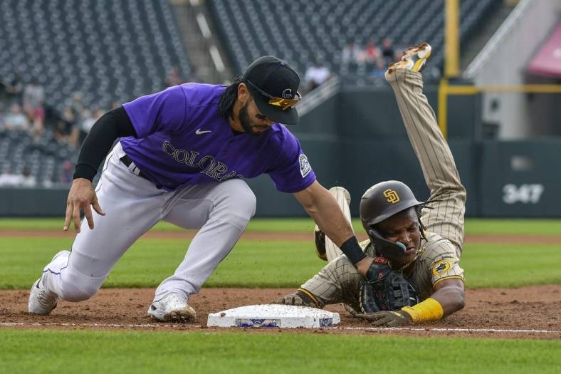 Jul 13, 2022; Denver, Colorado, USA; San Diego Padres shortstop C.J. Abrams (right) is picked off at first base by Colorado Rockies first baseman Connor Joe (left) in the second inning at Coors Field. Mandatory Credit: John Leyba-USA TODAY Sports