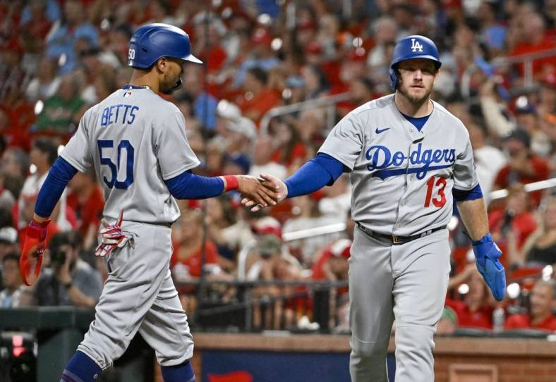 Jul 13, 2022; St. Louis, Missouri, USA;  Los Angeles Dodgers third baseman Max Muncy (13) celebrates with right fielder Mookie Betts (50) after they both scored on a  single by shortstop Trea Turner (not pictured) against the St. Louis Cardinals during the eighth inning at Busch Stadium. Mandatory Credit: Jeff Curry-USA TODAY Sports
