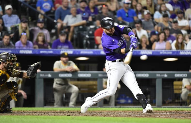 Jul 13, 2022; Denver, Colorado, USA; Colorado Rockies shortstop Jose Iglesias (11) hits a two run RBI in the seventh inning against the San Diego Padres at Coors Field. Iglesias ended the game with a 6 RBI night. Mandatory Credit: John Leyba-USA TODAY Sports