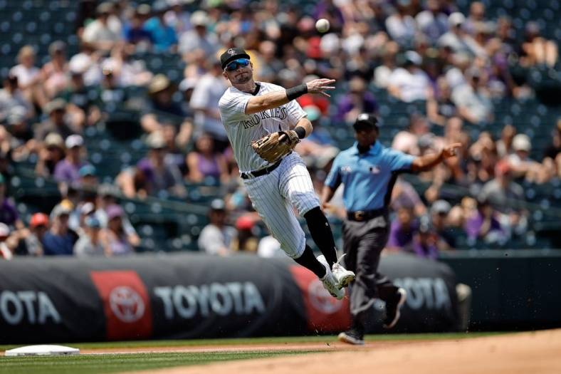 Jul 14, 2022; Denver, Colorado, USA; Colorado Rockies third baseman Garrett Hampson (1) makes a throw to first for an out in the first inning against the San Diego Padres at Coors Field. Mandatory Credit: Isaiah J. Downing-USA TODAY Sports