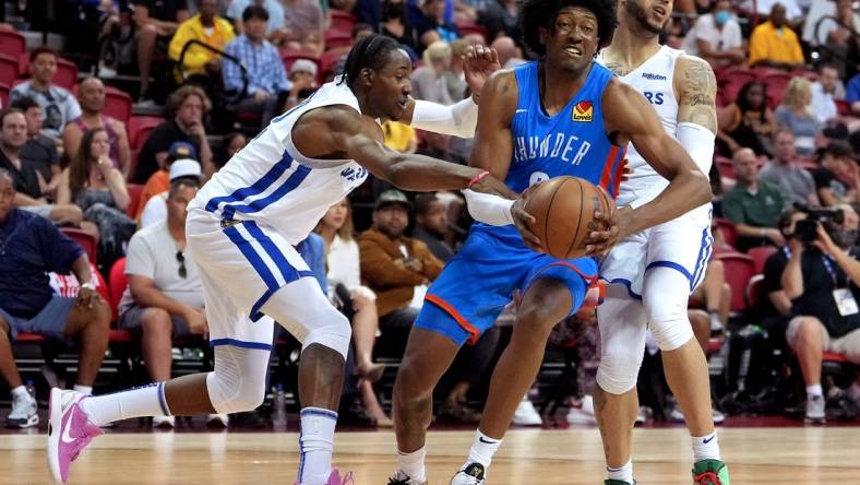 Jul 15, 2022; Las Vegas, NV, USA; Oklahoma City Thunder forward Jaylin Williams (6) drives between Golden State Warriors forward Jonathan Kuminga (0) and Golden State Warriors guard Quinndary Weatherspoon (12) during an NBA Summer League game at Thomas & Mack Center. Mandatory Credit: Stephen R. Sylvanie-USA TODAY Sports