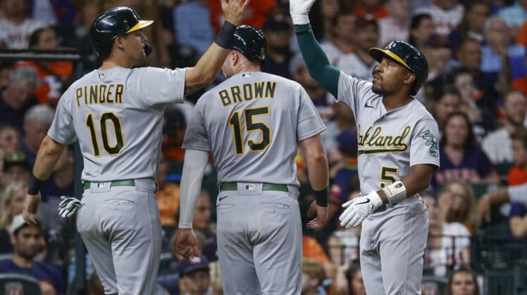 Jul 15, 2022; Houston, Texas, USA; Oakland Athletics left fielder Tony Kemp (5) celebrates with designated hitter Chad Pinder (10) and first baseman Seth Brown (15) during the seventh inning against the Houston Astros  at Minute Maid Park. Mandatory Credit: Troy Taormina-USA TODAY Sports