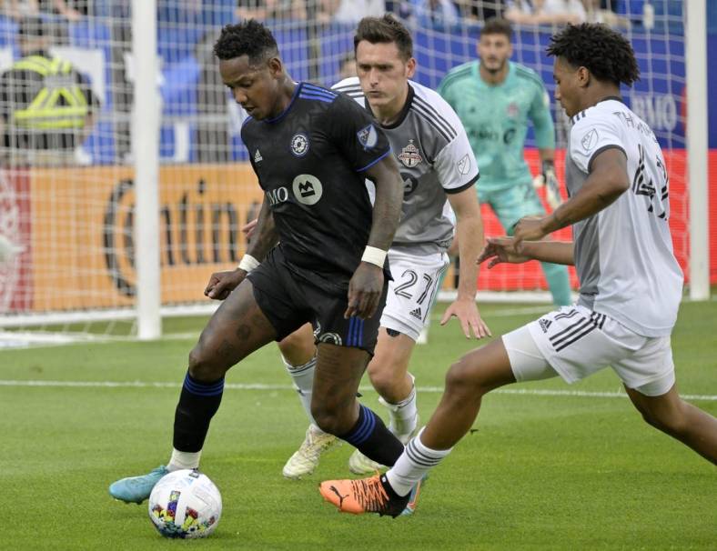 Jul 16, 2022; Montreal, Quebec, CAN; CF Montreal midfielder Romell Quioto (30) controls the ball against Toronto FC defender Shane O'Neill (27) and midfielder Kosi Thompson (47) during the first half at Stade Saputo. Mandatory Credit: Eric Bolte-USA TODAY Sports