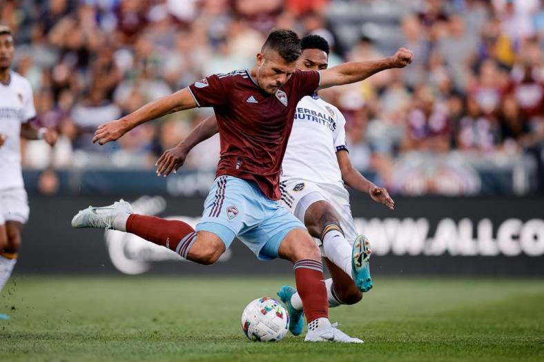Jul 16, 2022; Commerce City, Colorado, USA; Colorado Rapids midfielder Diego Rubio (11) scores on a shot as LA Galaxy midfielder Rayan Raveloson (6) defends in the first half at Dick's Sporting Goods Park. Mandatory Credit: Isaiah J. Downing-USA TODAY Sports