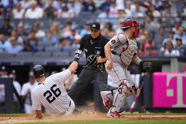 Jul 17, 2022; Bronx, New York, USA; New York Yankees second baseman DJ LeMahieu (26) scores a run on an errant throw to Boston Red Sox catcher Christian Vazquez (7) during the first inning at Yankee Stadium. Mandatory Credit: Gregory Fisher-USA TODAY Sports