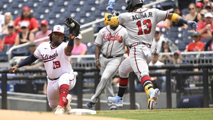 Jul 17, 2022; Washington, District of Columbia, USA;  Washington Nationals first baseman Josh Bell (19) reaches to make a catch at first base as Atlanta Braves right fielder Ronald Acuna Jr. (13) stretches for the base during the first inning at Nationals Park. Mandatory Credit: James A. Pittman-USA TODAY Sports