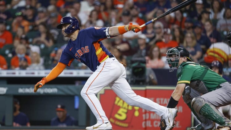 Jul 17, 2022; Houston, Texas, USA; Houston Astros left fielder Aledmys Diaz (16) hits a single during the first inning against the Oakland Athletics at Minute Maid Park. Mandatory Credit: Troy Taormina-USA TODAY Sports