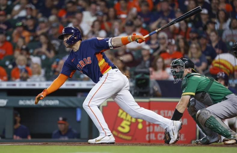 Jul 17, 2022; Houston, Texas, USA; Houston Astros left fielder Aledmys Diaz (16) hits a single during the first inning against the Oakland Athletics at Minute Maid Park. Mandatory Credit: Troy Taormina-USA TODAY Sports
