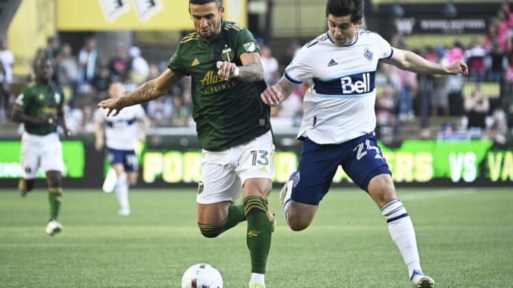 Jul 17, 2022; Portland, Oregon, USA; Portland Timbers defender Dario Zuparic (13) defends Vancouver Whitecaps forward Brian White (24) during the first half at Providence Park. Mandatory Credit: Troy Wayrynen-USA TODAY Sports
