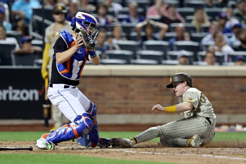 Jul 22, 2022; New York City, New York, USA; San Diego Padres second baseman Jake Cronenworth (9) scores ahead of the tag by New York Mets catcher Patrick Mazeika (4) on a fielder's choice by Padres right fielder Nomar Mazara (not pictured) and error by Mazeika during the seventh inning at Citi Field. Mandatory Credit: Brad Penner-USA TODAY Sports