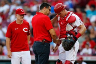 Cincinnati Reds catcher Tyler Stephenson (37) is examined by team trainer Tomas Vera after being hit in the arm by a foul ball in the first inning of the MLB National League game between the Cincinnati Reds and the St. Louis Cardinals at Great American Ball Park in downtown Cincinnati on Friday, July 22, 2022.St Louis Cardinals At Cincinnati Reds