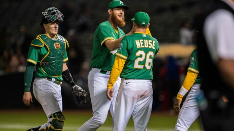 Jul 22, 2022; Oakland, California, USA;  Oakland Athletics relief pitcher A.J. Puk (33) celebrates with Oakland Athletics designated hitter Sheldon Neuse (26) after the game against the Texas Rangers at RingCentral Coliseum. Mandatory Credit: Neville E. Guard-USA TODAY Sports