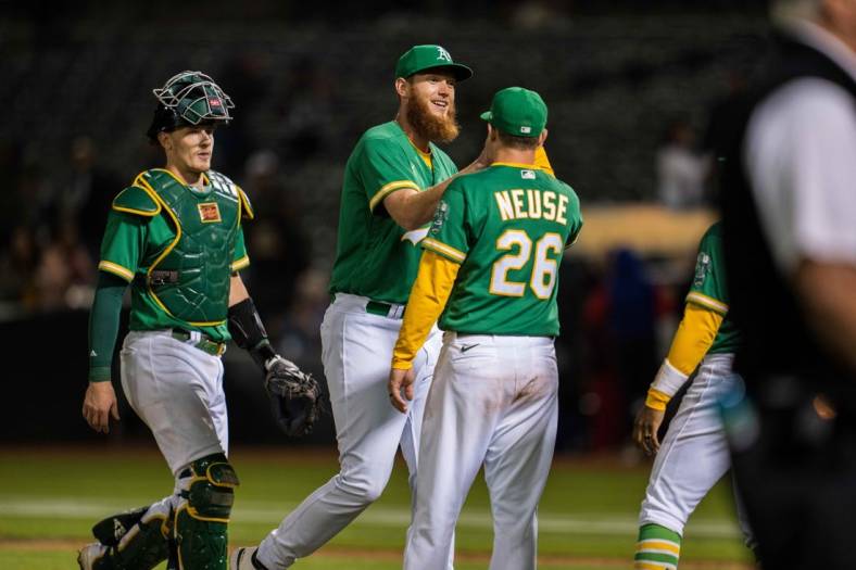 Jul 22, 2022; Oakland, California, USA;  Oakland Athletics relief pitcher A.J. Puk (33) celebrates with Oakland Athletics designated hitter Sheldon Neuse (26) after the game against the Texas Rangers at RingCentral Coliseum. Mandatory Credit: Neville E. Guard-USA TODAY Sports