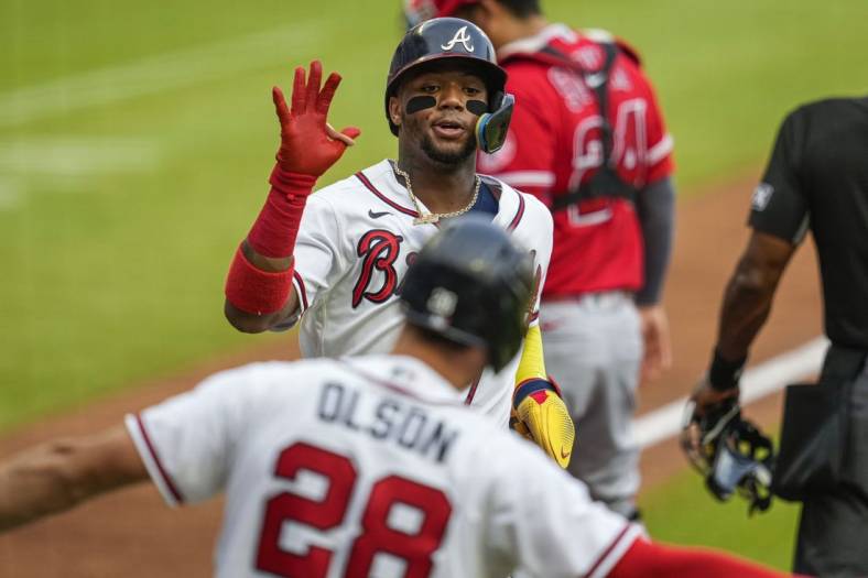 Jul 23, 2022; Cumberland, Georgia, USA; Atlanta Braves right fielder Ronald Acuna Jr. (13) reacts with first baseman Matt Olson (28) after scoring a run against the Los Angeles Angels during the first inning at Truist Park. Mandatory Credit: Dale Zanine-USA TODAY Sports
