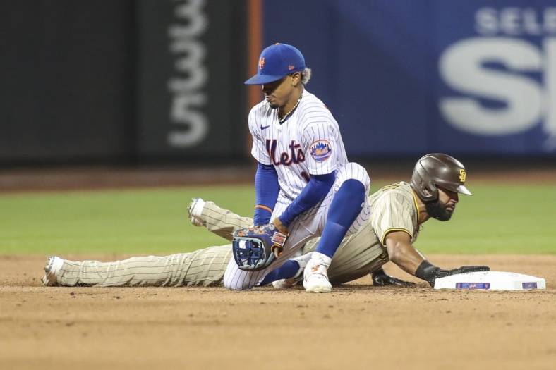Jul 23, 2022; New York City, New York, USA;  New York Mets shortstop Francisco Lindor (12) holds onto the ball after a pick off attempt against San Diego Padres right fielder Nomar Mazara (16) in the fifth inning at Citi Field. Mandatory Credit: Wendell Cruz-USA TODAY Sports