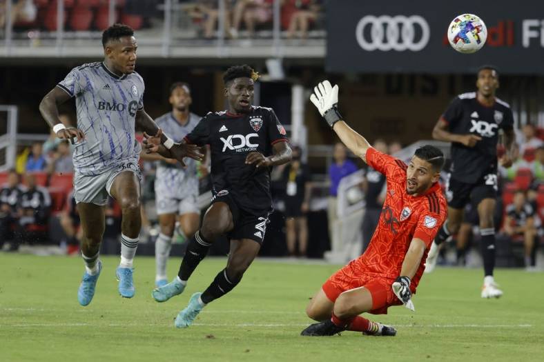 Jul 23, 2022; Washington, District of Columbia, USA; CF Montr al forward Romell Quioto (30) scores a goal on D.C. United goalkeeper Rafael Romo (1) as D.C. United defender Gaoussou Samak  (2) defends in the first half at Audi Field. Mandatory Credit: Geoff Burke-USA TODAY Sports