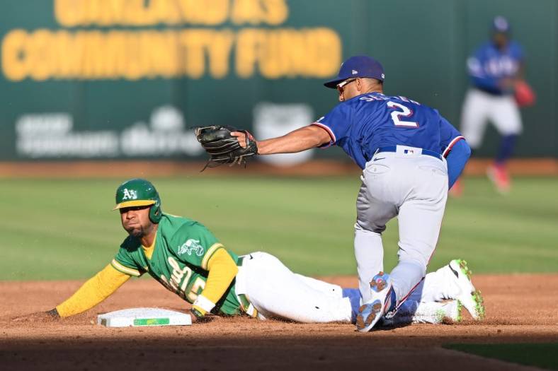 Jul 23, 2022; Oakland, California, USA; Texas Rangers second baseman Marcus Semien (2) tags out Oakland Athletics shortstop Elvis Andrus (17) on a steal attempt during the second inning at RingCentral Coliseum. Mandatory Credit: Robert Edwards-USA TODAY Sports