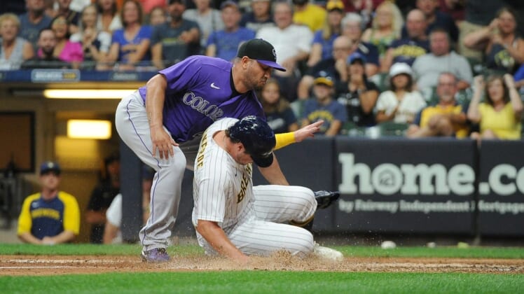 Jul 23, 2022; Milwaukee, Wisconsin, USA; Milwaukee Brewers right fielder Hunter Renfroe (12) scores on a wild pitch as Colorado Rockies relief pitcher Jhoulys Chacin (43) covers the plate in the sixth inning at American Family Field. Mandatory Credit: Michael McLoone-USA TODAY Sports