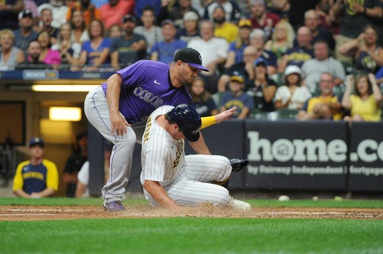Jul 23, 2022; Milwaukee, Wisconsin, USA; Milwaukee Brewers right fielder Hunter Renfroe (12) scores on a wild pitch as Colorado Rockies relief pitcher Jhoulys Chacin (43) covers the plate in the sixth inning at American Family Field. Mandatory Credit: Michael McLoone-USA TODAY Sports