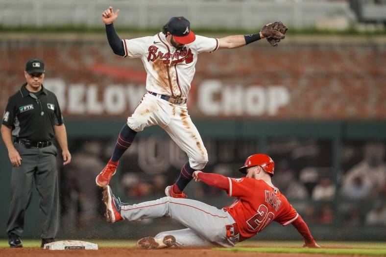 Jul 23, 2022; Cumberland, Georgia, USA; Atlanta Braves shortstop Dansby Swanson (7) has to jump over a sliding Los Angeles Angels first baseman Jared Walsh (20) during the sixth inning at Truist Park. Mandatory Credit: Dale Zanine-USA TODAY Sports