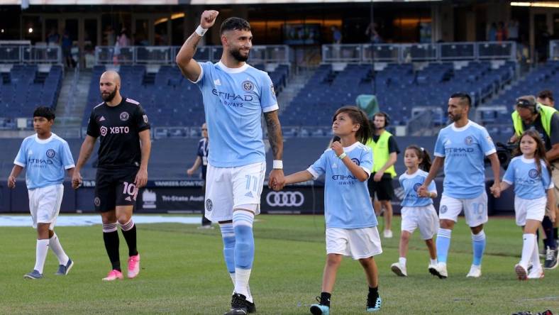 Jul 23, 2022; New York, New York, USA; New York City FC midfielder Valentin Castellanos (11) reacts as he is escorted onto the pitch by a young fan before a match against Inter Miami CF at Yankee Stadium. Mandatory Credit: Brad Penner-USA TODAY Sports