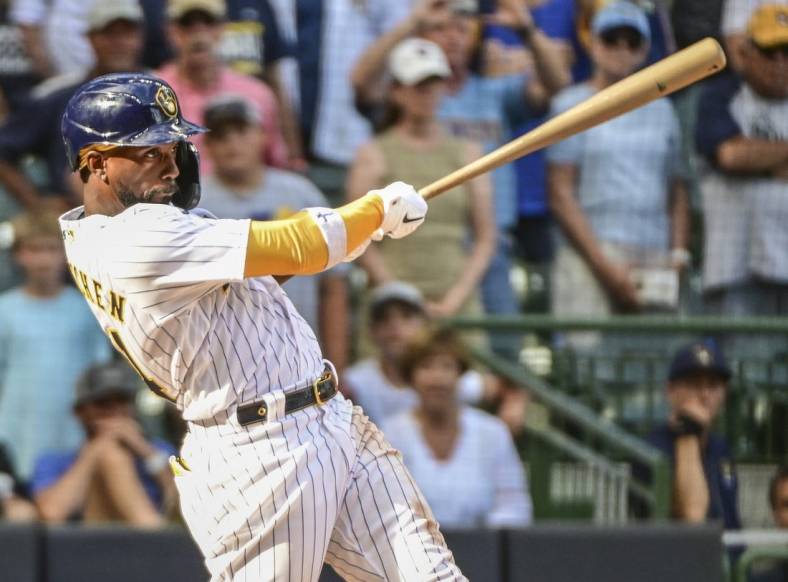 Jul 24, 2022; Milwaukee, Wisconsin, USA; Milwaukee Brewers designated hitter Andrew McCutchen (24) hits a RBI double in the eighth inning against the Colorado Rockies at American Family Field. Mandatory Credit: Benny Sieu-USA TODAY Sports