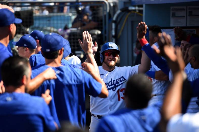 Jul 24, 2022; Los Angeles, California, USA; Los Angeles Dodgers third baseman Max Muncy (13) celebrates with his team in the dug out after scoring a run against the San Francisco Giants during the seventh inning at Dodger Stadium. Mandatory Credit: Jonathan Hui-USA TODAY Sports