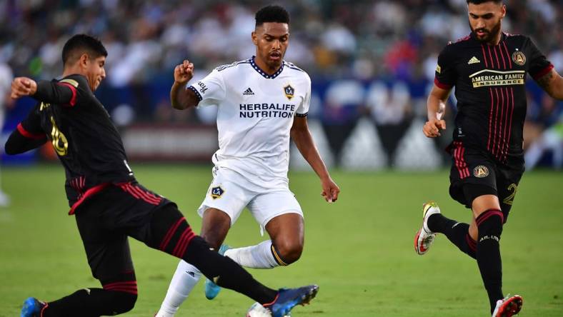 Jul 24, 2022; Carson, California, USA; Los Angeles Galaxy midfielder Rayan Raveloson (6) moves the ball against Atlanta United defender Alan Franco (6) and defender Juan Jose Purata (22) during the first half at Dignity Health Sports Park. Mandatory Credit: Gary A. Vasquez-USA TODAY Sports