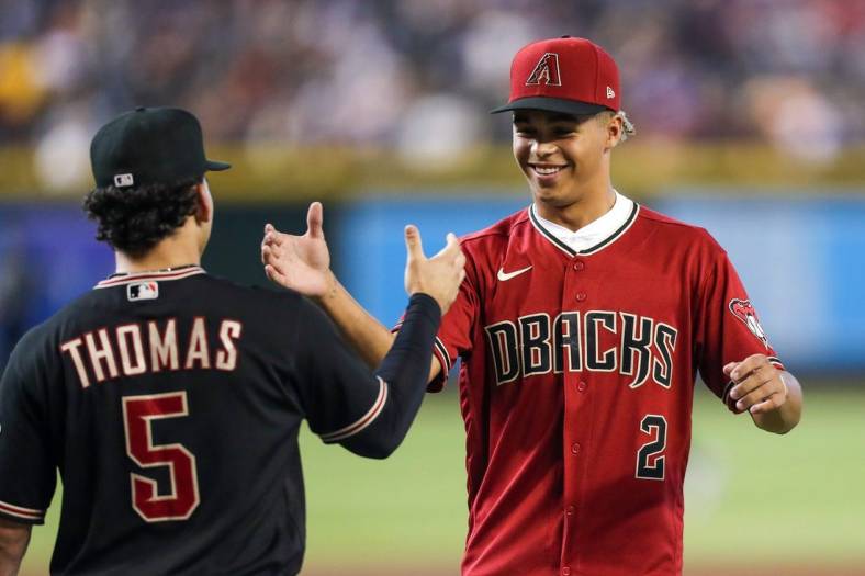 Diamondbacks Draft Druw Jones, right, shakes hands with Arizona Diamondbacks center fielder Alek Thomas (5), left, after throwing the opening pitch before the game against the Washington Nationals at Chase Field on Saturday, July 23, 2022, in Phoenix.

Uscp 7lzxvqcipg7dt8x01rk2 Original