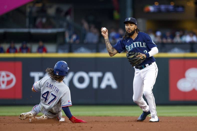 Jul 25, 2022; Seattle, Washington, USA; Seattle Mariners shortstop J.P. Crawford (3) holds back from throwing to first base after getting a force out against Texas Rangers left fielder Josh Smith (47) during the third inning at T-Mobile Park. Mandatory Credit: Joe Nicholson-USA TODAY Sports