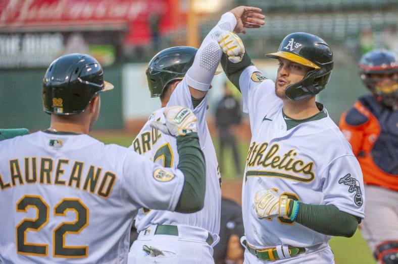 Jul 26, 2022; Oakland, California, USA; Oakland Athletics left fielder Chad Pinder (10) celebrates with third baseman Jonah Bride (77) and right fielder Ramon Laureano (22) after hitting a grand slam during the third inning against the Houston Astros at RingCentral Coliseum. Mandatory Credit: Ed Szczepanski-USA TODAY Sports