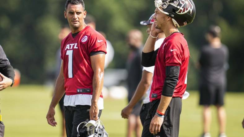 Jul 27, 2022; Flowery Branch, GA, USA; Atlanta Falcons quarterbacks Marcus Mariota (1) and Desmond Ridder (4) talk on the field during training camp at IBM Performance Field. Mandatory Credit: Dale Zanine-USA TODAY Sports