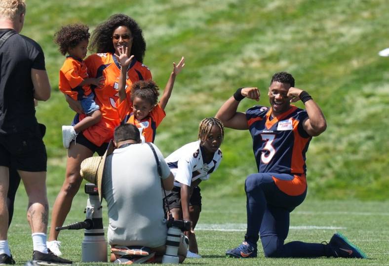 Jul 27, 2022; Englewood, CO, USA; Denver Broncos quarterback Russell Wilson (3) and wife his Ciara Wilson pose for photos with their children following training camp at the UCHealth Training Center. Mandatory Credit: Ron Chenoy-USA TODAY Sports