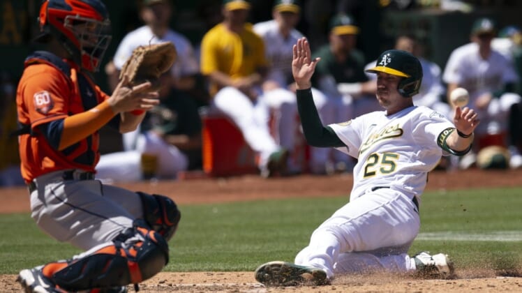 Jul 27, 2022; Oakland, California, USA; Oakland Athletics left fielder Stephen Piscotty (25) slides safely home ahead of the relay to Houston Astros catcher Korey Lee (38) on an RBI single by Skye Bolt during the seventh inning at RingCentral Coliseum. Mandatory Credit: D. Ross Cameron-USA TODAY Sports