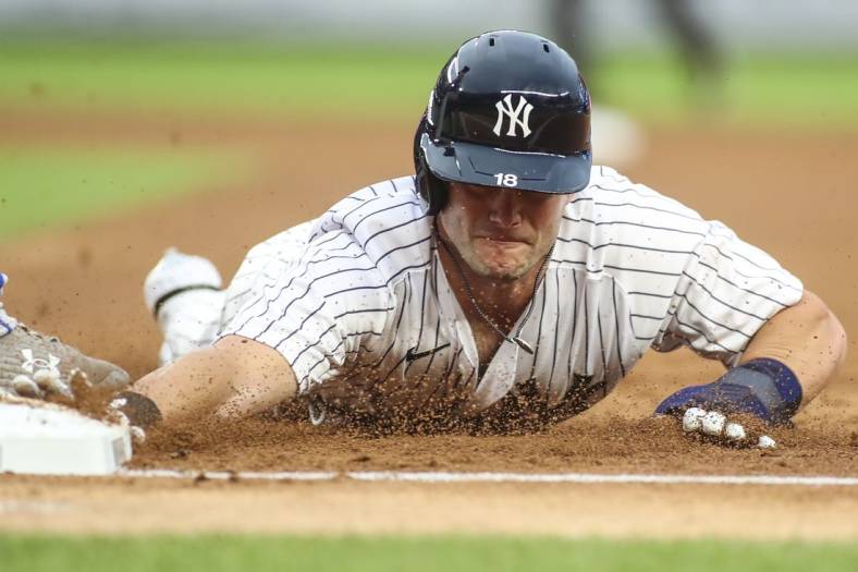 Jul 29, 2022; Bronx, New York, USA;  New York Yankees left fielder Andrew Benintendi (18) dives back to first base on a pick off attempt in the second inning against the Kansas City Royals at Yankee Stadium. Mandatory Credit: Wendell Cruz-USA TODAY Sports