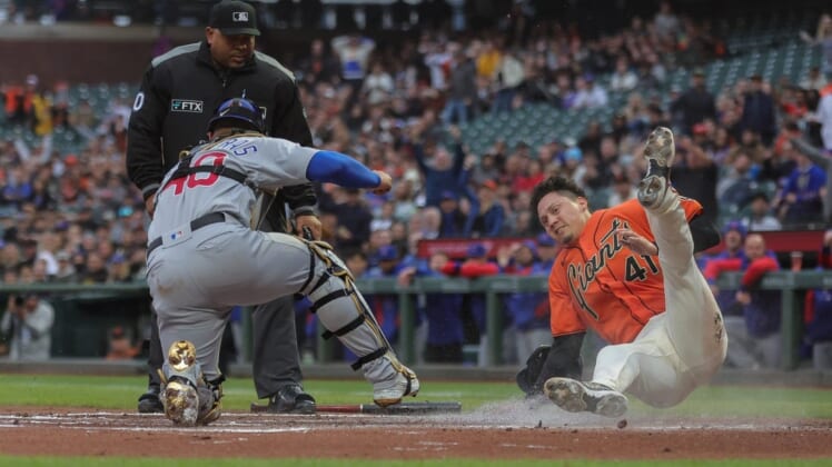 Jul 29, 2022; San Francisco, California, USA;  San Francisco Giants third baseman Wilmer Flores (41) gets tagged out at home plate by Chicago Cubs catcher Willson Contreras (40) during the first inning at Oracle Park. Mandatory Credit: Sergio Estrada-USA TODAY Sports