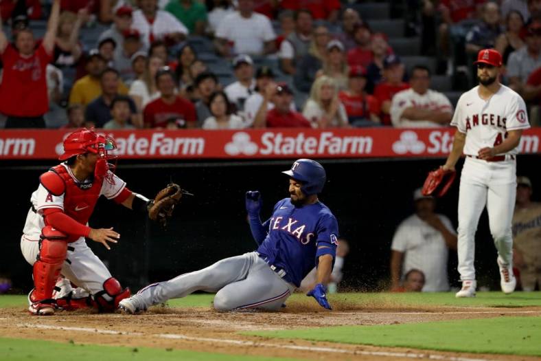 Jul 29, 2022; Anaheim, California, USA;  Texas Rangers shortstop Marcus Semien (2) scores on a double and fielding error by Los Angeles Angels left fielder Jo Adell (7) during the sixth inning at Angel Stadium. Mandatory Credit: Kiyoshi Mio-USA TODAY Sports