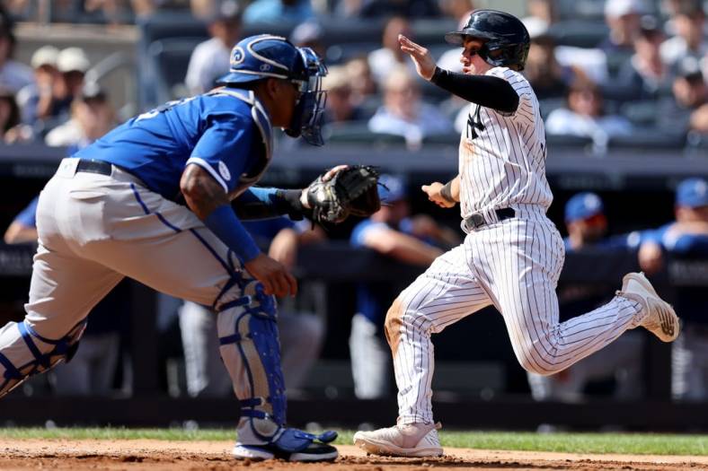 Jul 30, 2022; Bronx, New York, USA; New York Yankees catcher Jose Trevino (39) scores on a sacrifice fly by left fielder Andrew Benintendi (not pictured) in front of Kansas City Royals catcher Salvador Perez (13) during the fourth inning at Yankee Stadium. Mandatory Credit: Brad Penner-USA TODAY Sports