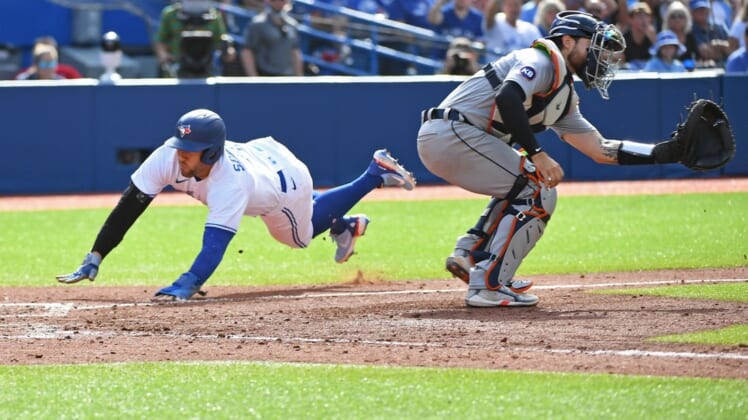 Jul 30, 2022; Toronto, Ontario, CAN; Toronto Blue Jays designated hitter George Springer (4) dives past Detroit Tigers catcher Eric Haase (13) to score in the sixth inning after a Toronto Blue Jays short stop Bo Bichette (11) (not shown) sacrifice fly at Rogers Centre. Mandatory Credit: Gerry Angus-USA TODAY Sports